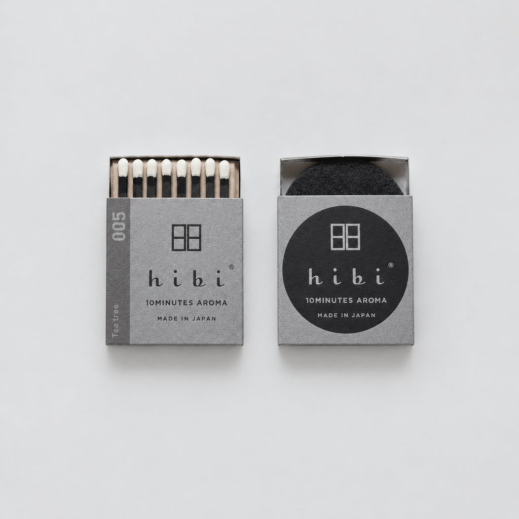 Two Hibi 10Minutes Aroma matches in gray packaging on a white background, one showing the white matches and the other showing a black circular insert.