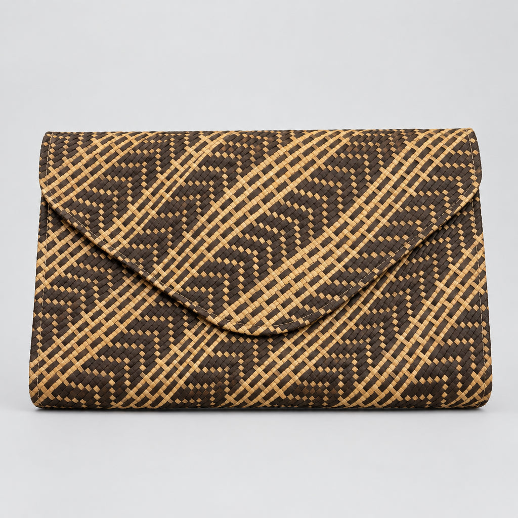 A rectangular clutch bag with an envelope-style flap, featuring a woven geometric pattern in dark brown and tan, laid flat on a light-colored fabric surface.
